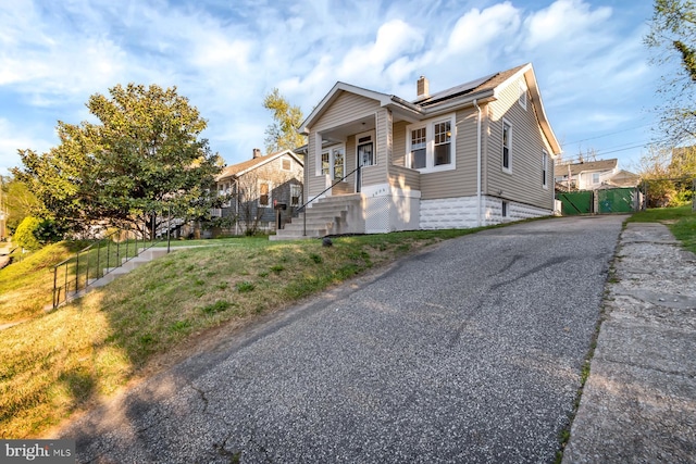 view of front of home with covered porch and a front lawn