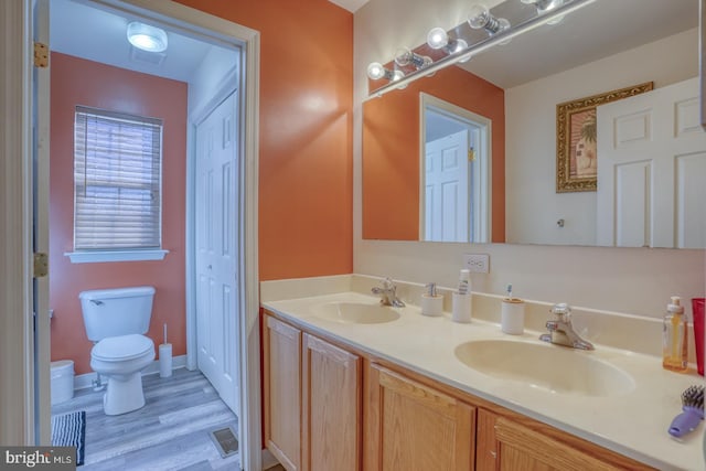 bathroom with toilet, vanity, and hardwood / wood-style flooring