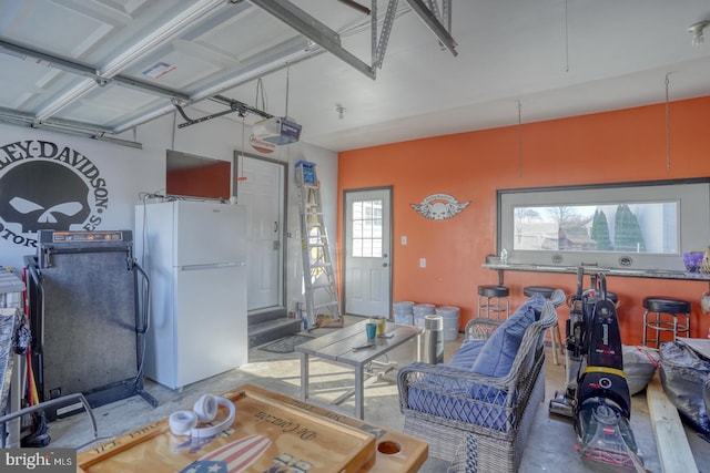 garage featuring a garage door opener and white refrigerator