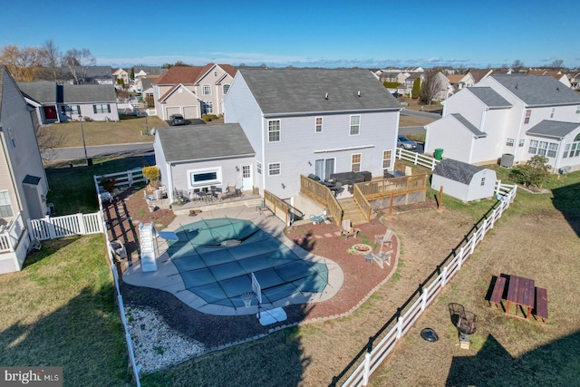 rear view of property featuring a patio, a pool side deck, and a lawn