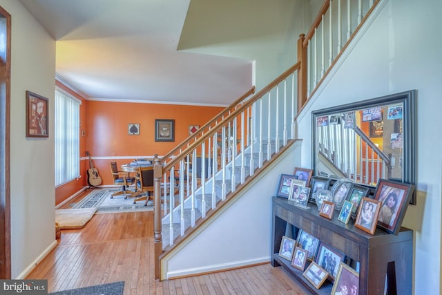 staircase with hardwood / wood-style flooring and ornamental molding