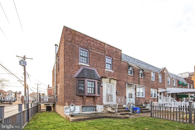 back of house with central AC unit and a lawn