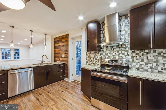 kitchen featuring sink, wall chimney range hood, stainless steel appliances, and dark brown cabinetry