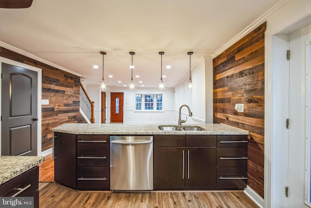 kitchen featuring dishwasher, dark brown cabinets, wood walls, and sink