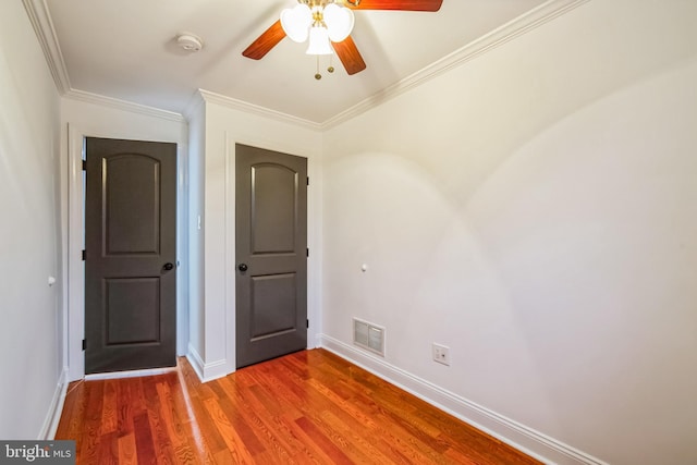 unfurnished bedroom featuring ceiling fan, crown molding, and hardwood / wood-style flooring