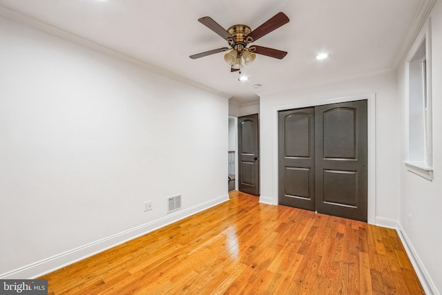 unfurnished bedroom with a closet, light hardwood / wood-style flooring, ceiling fan, and ornamental molding