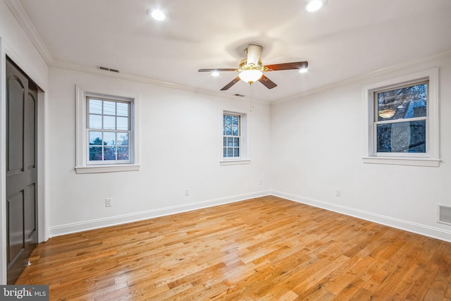 empty room with ceiling fan, wood-type flooring, and crown molding