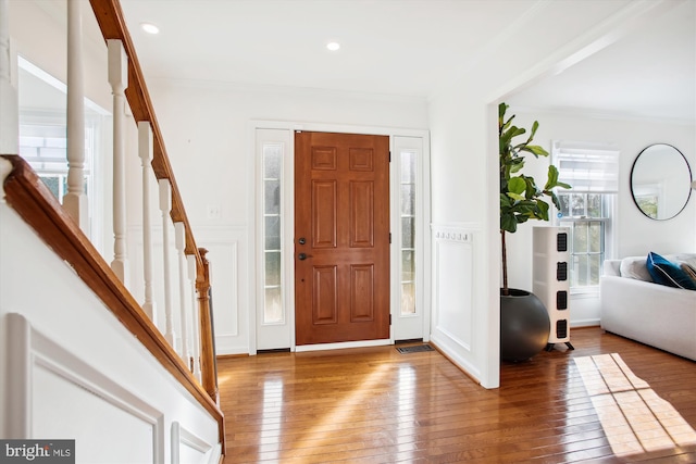 foyer entrance featuring hardwood / wood-style flooring and crown molding