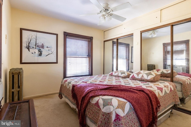 carpeted bedroom featuring two closets and ceiling fan