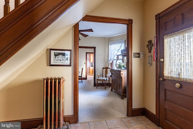 hall featuring radiator heating unit and light colored carpet