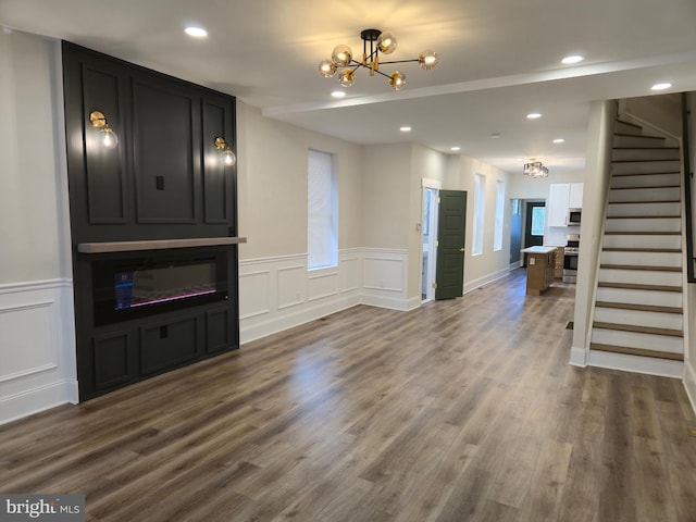 living room with dark wood-type flooring, stairway, recessed lighting, and a notable chandelier