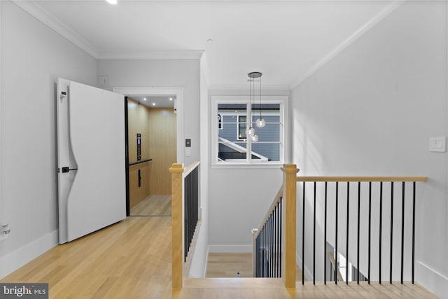 staircase featuring wood-type flooring, an inviting chandelier, and ornamental molding