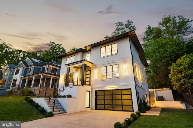 contemporary home featuring a lawn and a garage