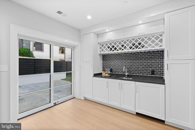 kitchen featuring white cabinets, light hardwood / wood-style flooring, and sink