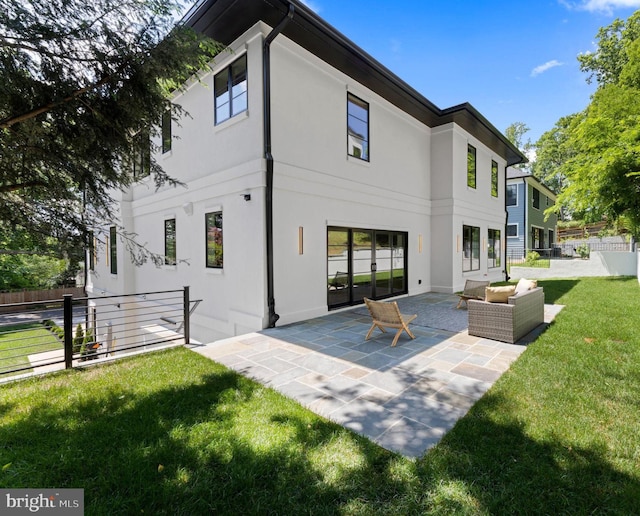 back of property with outdoor lounge area, a patio area, and a lawn