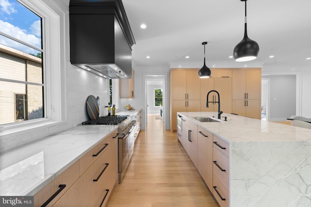 kitchen with high end range, light stone countertops, a spacious island, light brown cabinets, and decorative light fixtures