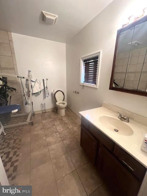 bathroom with vanity, tile patterned flooring, and toilet