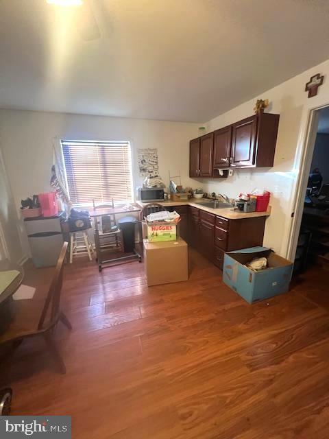 kitchen featuring hardwood / wood-style floors, dark brown cabinets, and sink