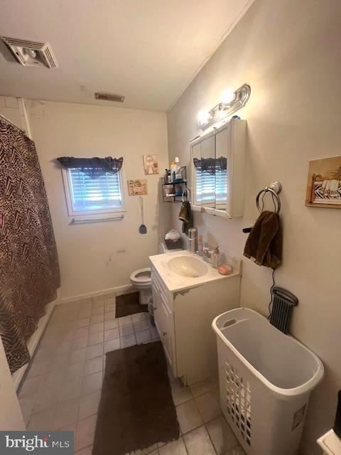 bathroom with a healthy amount of sunlight, vanity, and toilet