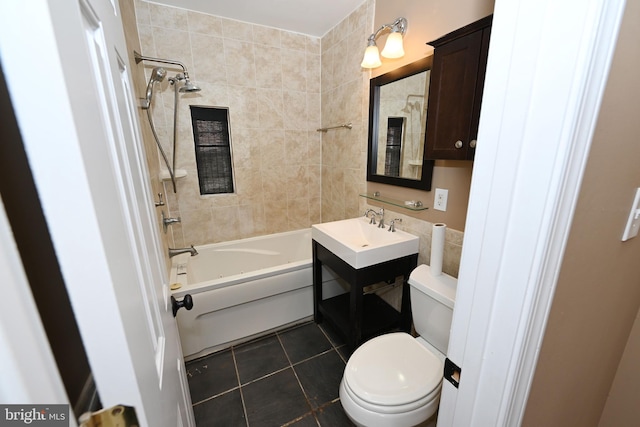 full bathroom featuring tile patterned flooring, toilet, vanity, and tiled shower / bath