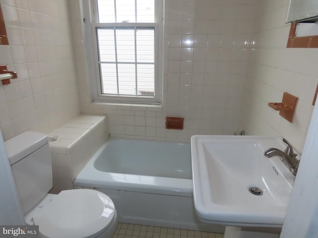 bathroom with tile patterned flooring, a washtub, a healthy amount of sunlight, and sink