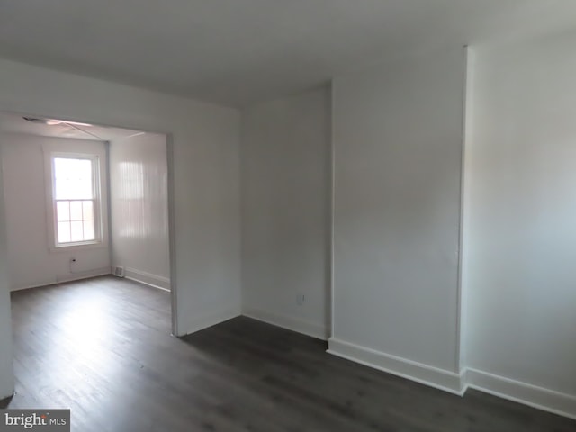 unfurnished room featuring dark wood-type flooring