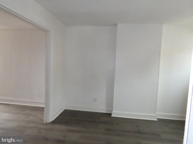 spare room featuring dark wood-type flooring