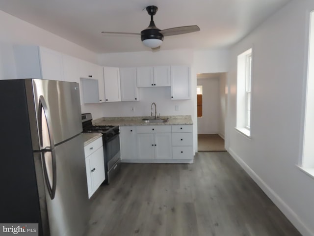 kitchen featuring gas stove, stainless steel refrigerator, ceiling fan, sink, and white cabinets