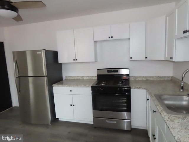 kitchen featuring light stone countertops, ceiling fan, sink, stainless steel appliances, and white cabinets