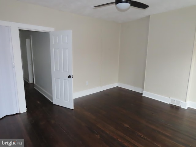 empty room with ceiling fan and dark wood-type flooring