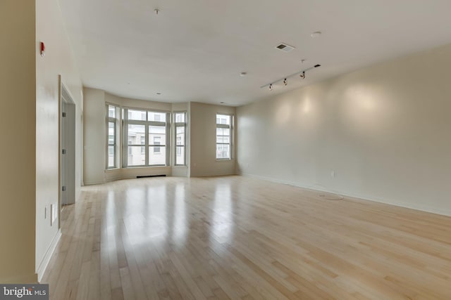 spare room featuring light hardwood / wood-style flooring and track lighting