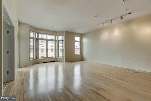 spare room featuring light wood-type flooring and rail lighting