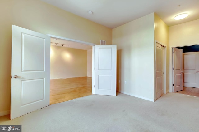 unfurnished bedroom featuring light colored carpet