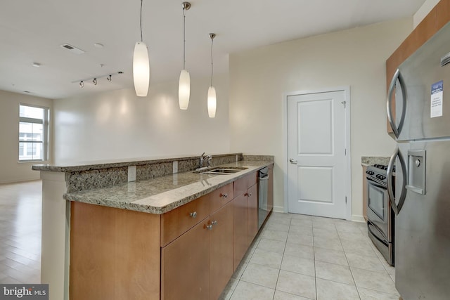 kitchen featuring sink, light tile patterned floors, decorative light fixtures, kitchen peninsula, and stainless steel appliances