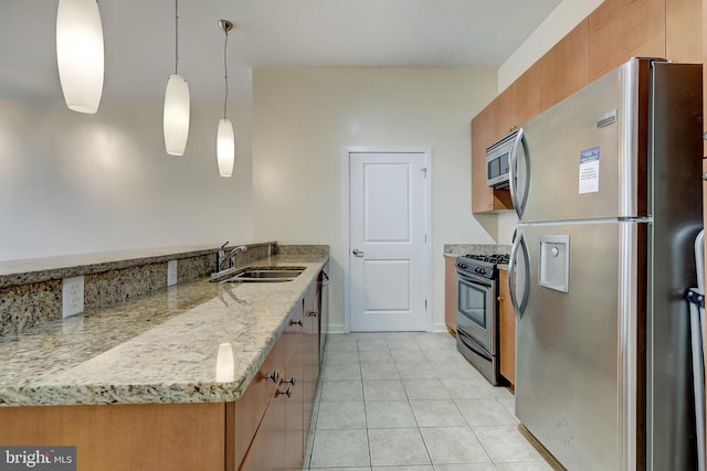 kitchen featuring appliances with stainless steel finishes, light stone counters, sink, hanging light fixtures, and light tile patterned flooring