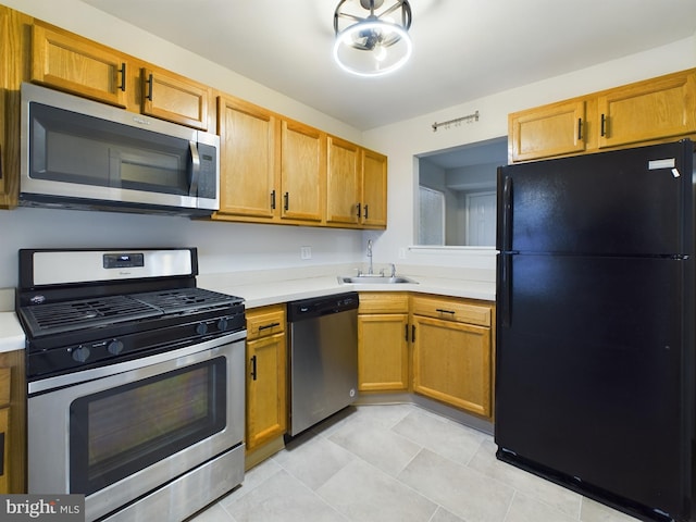 kitchen with light tile patterned flooring, appliances with stainless steel finishes, and sink