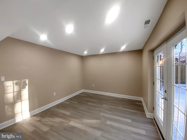 spare room featuring wood-type flooring and french doors