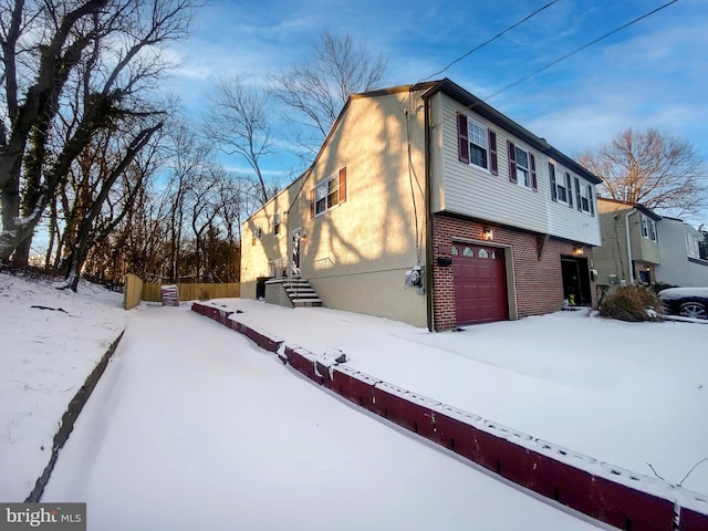 view of snowy exterior with a garage