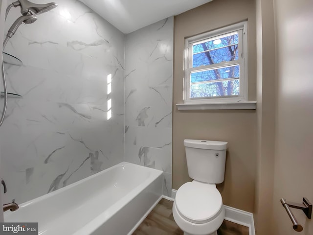 bathroom with wood-type flooring, toilet, and tiled shower / bath