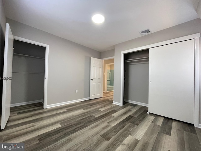 unfurnished bedroom with a closet and dark hardwood / wood-style flooring