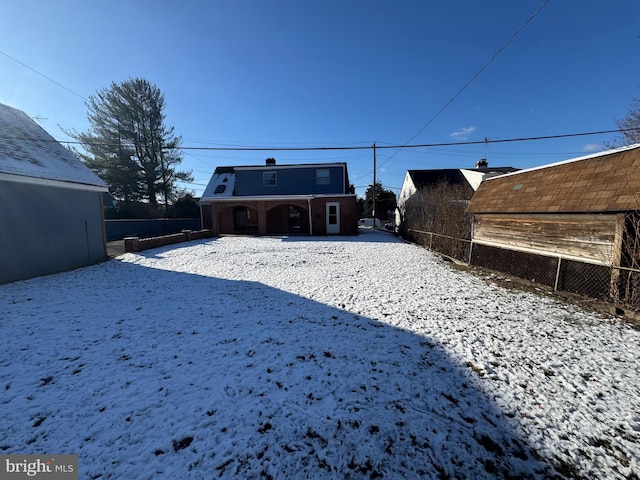 view of snow covered rear of property