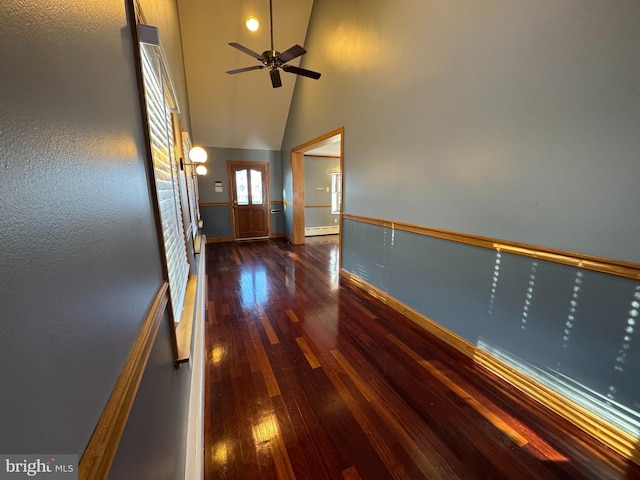 corridor featuring a baseboard heating unit, high vaulted ceiling, and dark wood-type flooring