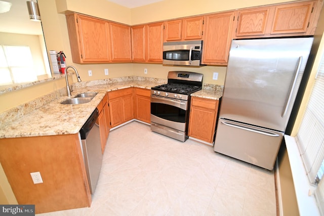 kitchen featuring light stone countertops, sink, and appliances with stainless steel finishes