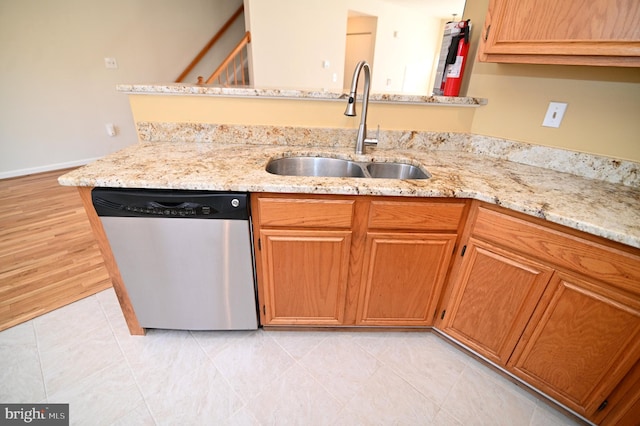 kitchen with light stone countertops, sink, stainless steel dishwasher, kitchen peninsula, and light tile patterned floors