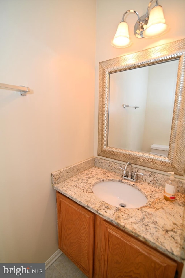 bathroom featuring tile patterned floors, vanity, and toilet