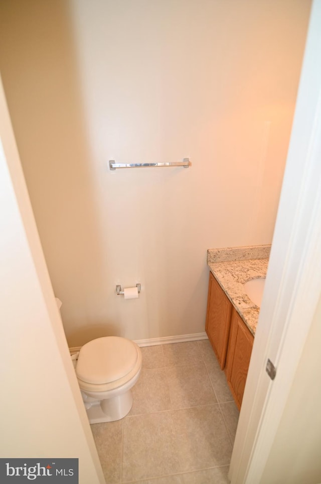 bathroom with tile patterned flooring, vanity, and toilet