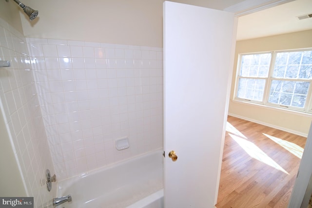 bathroom featuring hardwood / wood-style flooring and tiled shower / bath