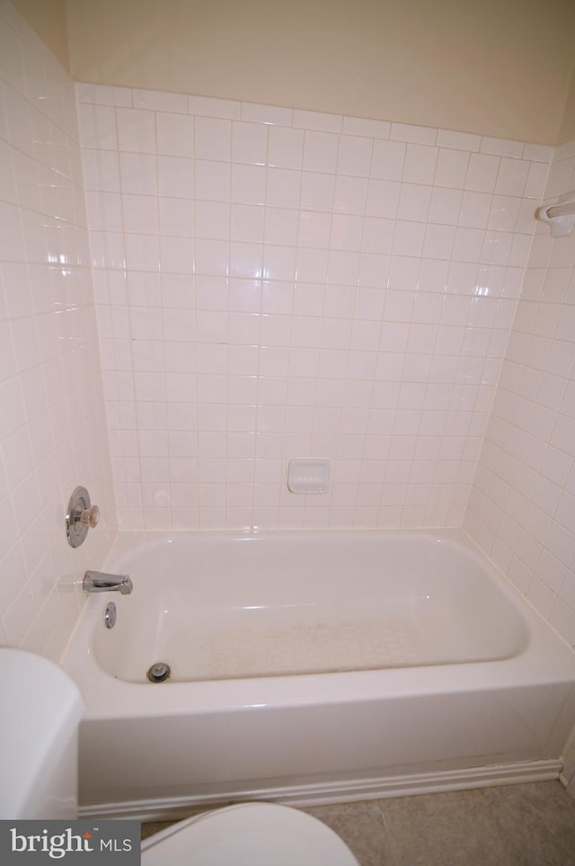 bathroom with tile patterned flooring, shower / bathtub combination, and toilet