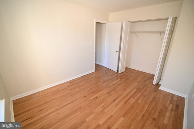 unfurnished bedroom with light hardwood / wood-style flooring and a closet