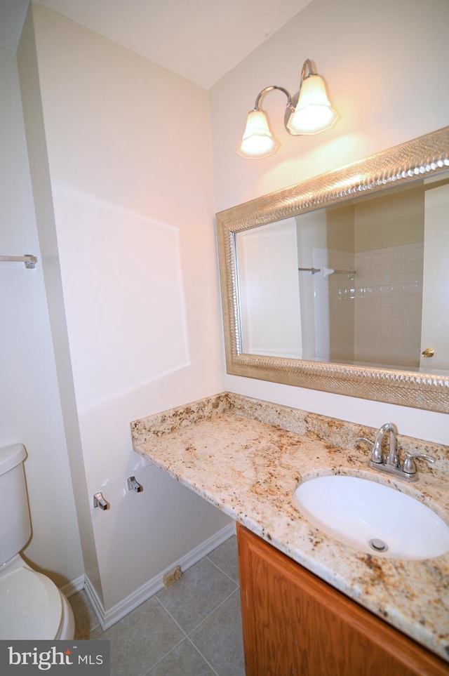 bathroom featuring tile patterned flooring, vanity, and toilet